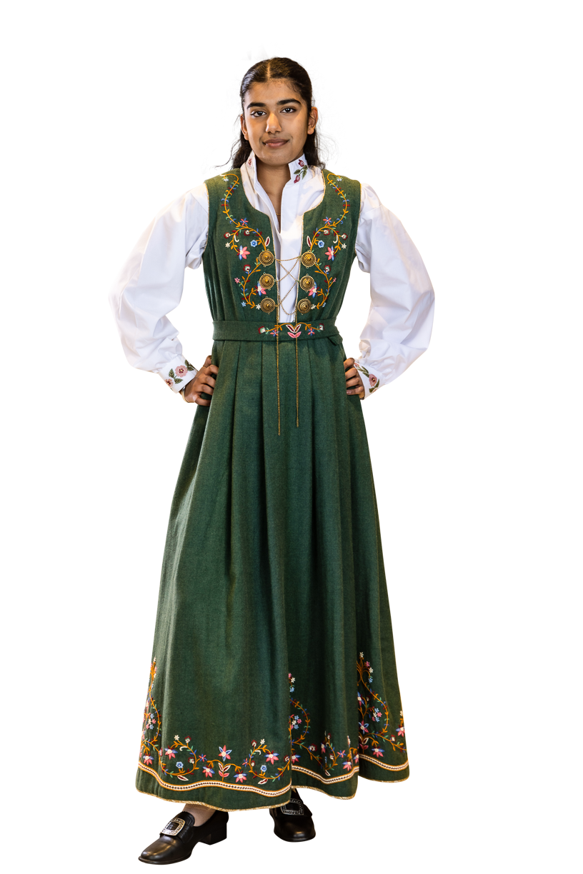 Håndbrodert drakt i nydelig grønnfarge inspirert av grønneenger. Broderiene er inspirert av sommerblomster. Hele drakte i hel figur.
