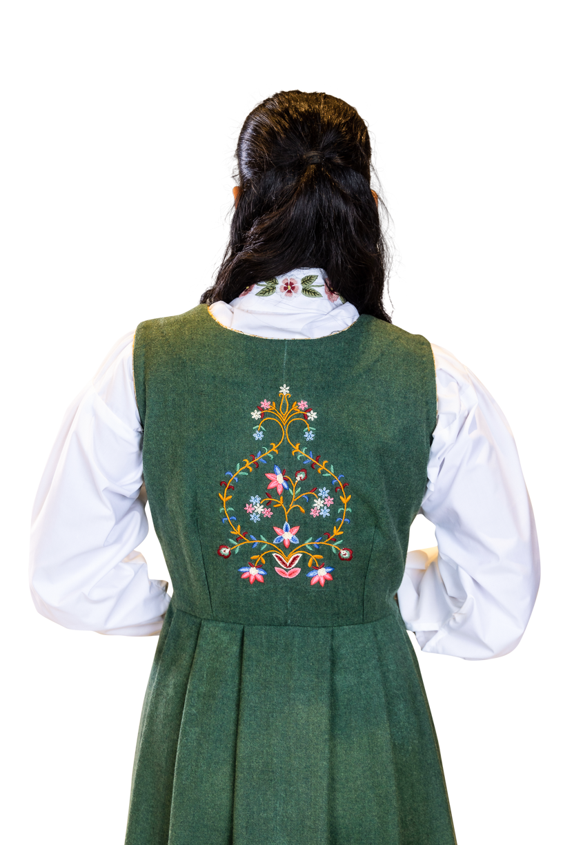 Håndbrodert drakt i nydelig grønnfarge inspirert av grønneenger. Broderiene er inspirert av sommerblomster.